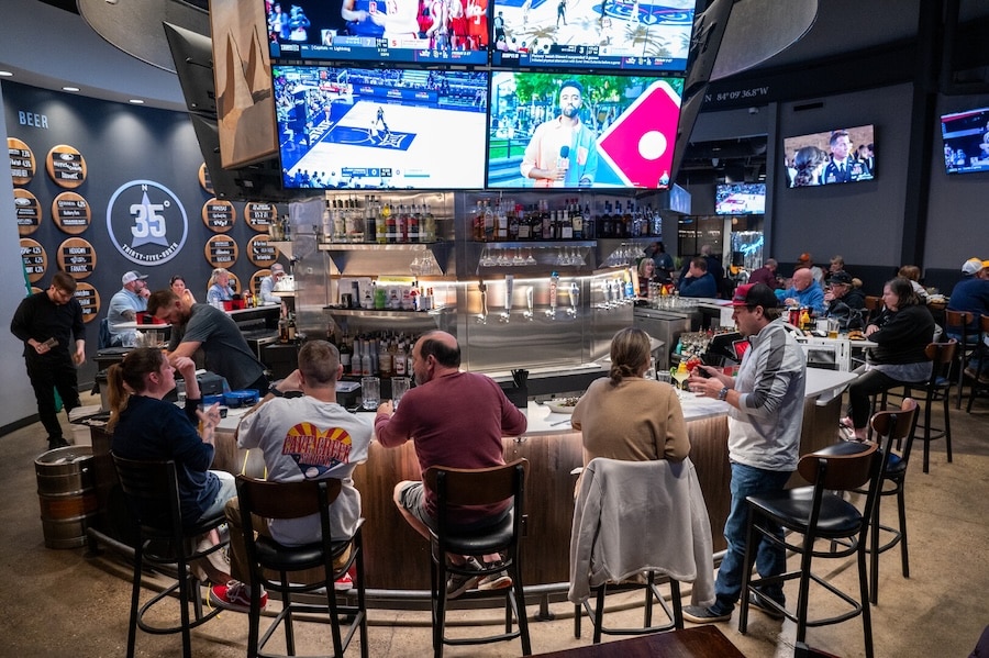 People sitting at the bar watching tv at 35 North Bar and Grill