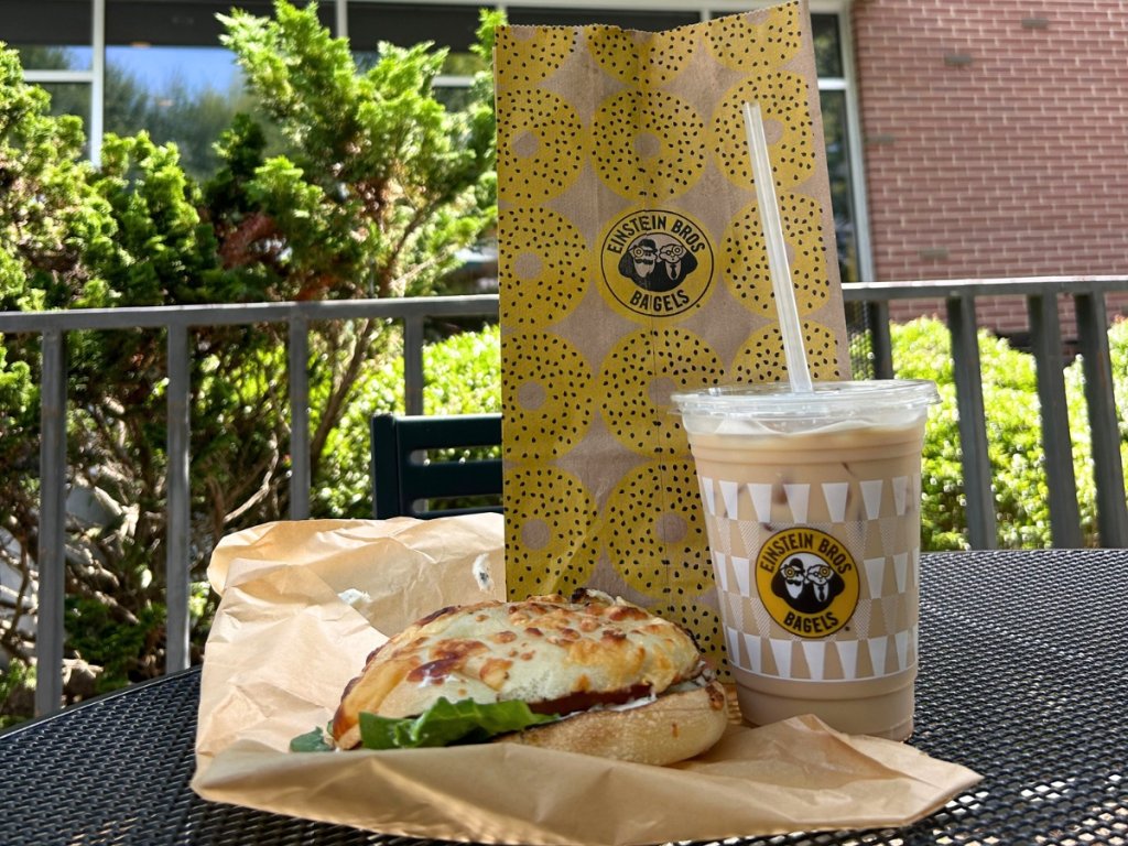 lunch bagel and iced coffee on the patio table at einstein bros bagels