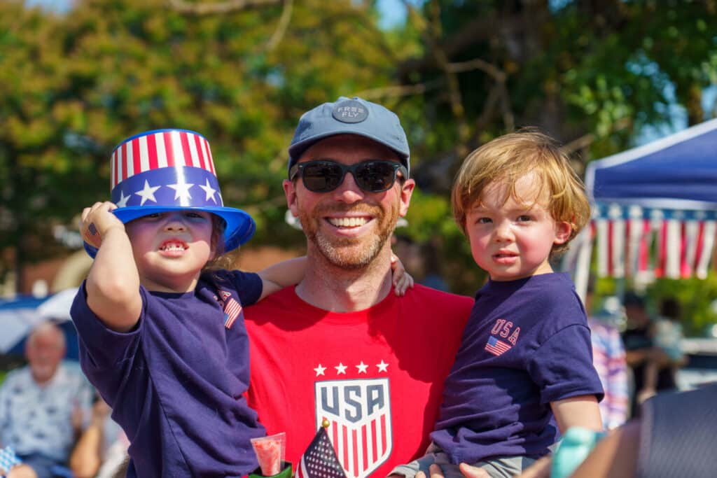 Dad and kids smiling at Fourth of July Parade in Farragut