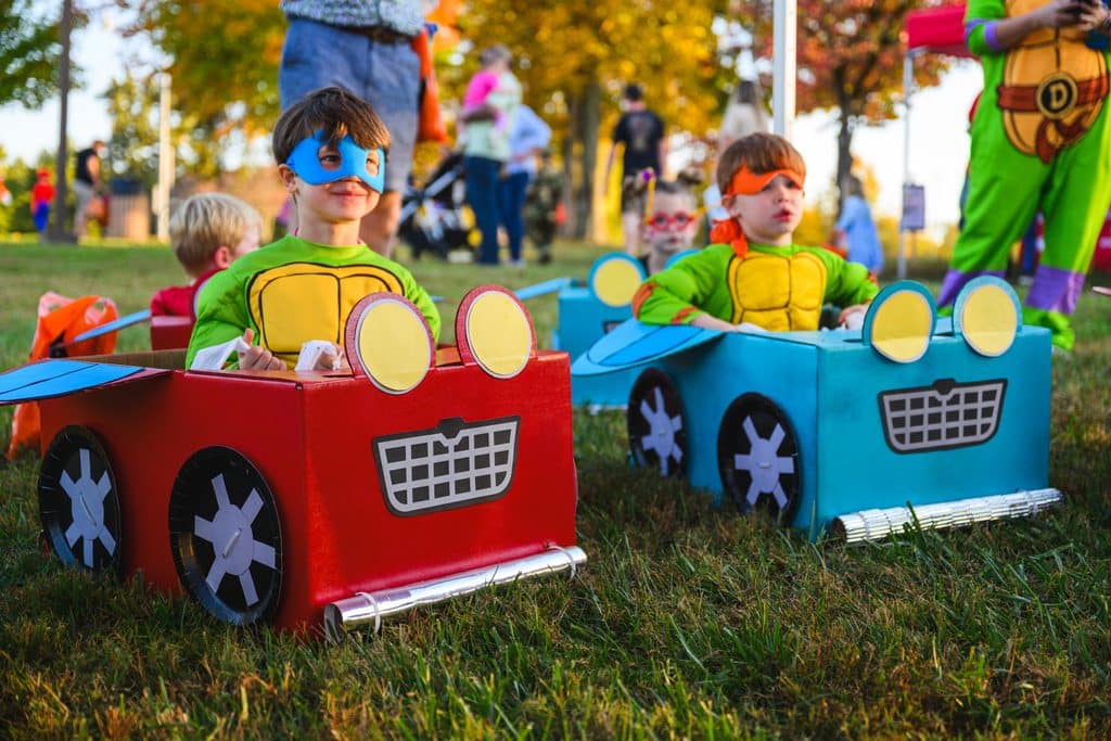 Freaky Friday Halloween Parks & Rec, two kids dressed as teenage mutant ninja turtles sitting in cardboard cars