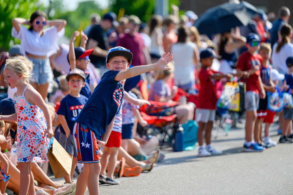 Kid waving at 4th of July parade