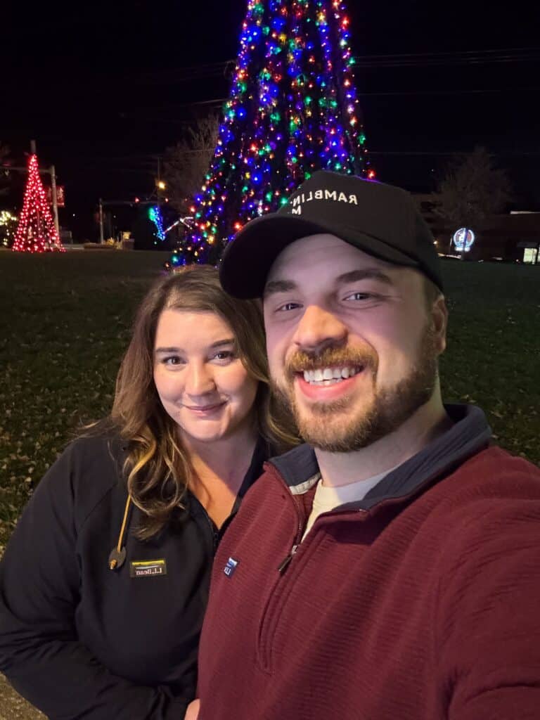 couple smiling taking a selfie in front of christmas tree at light the park in farragut holiday light display free knoxville family friendly things to do founders park