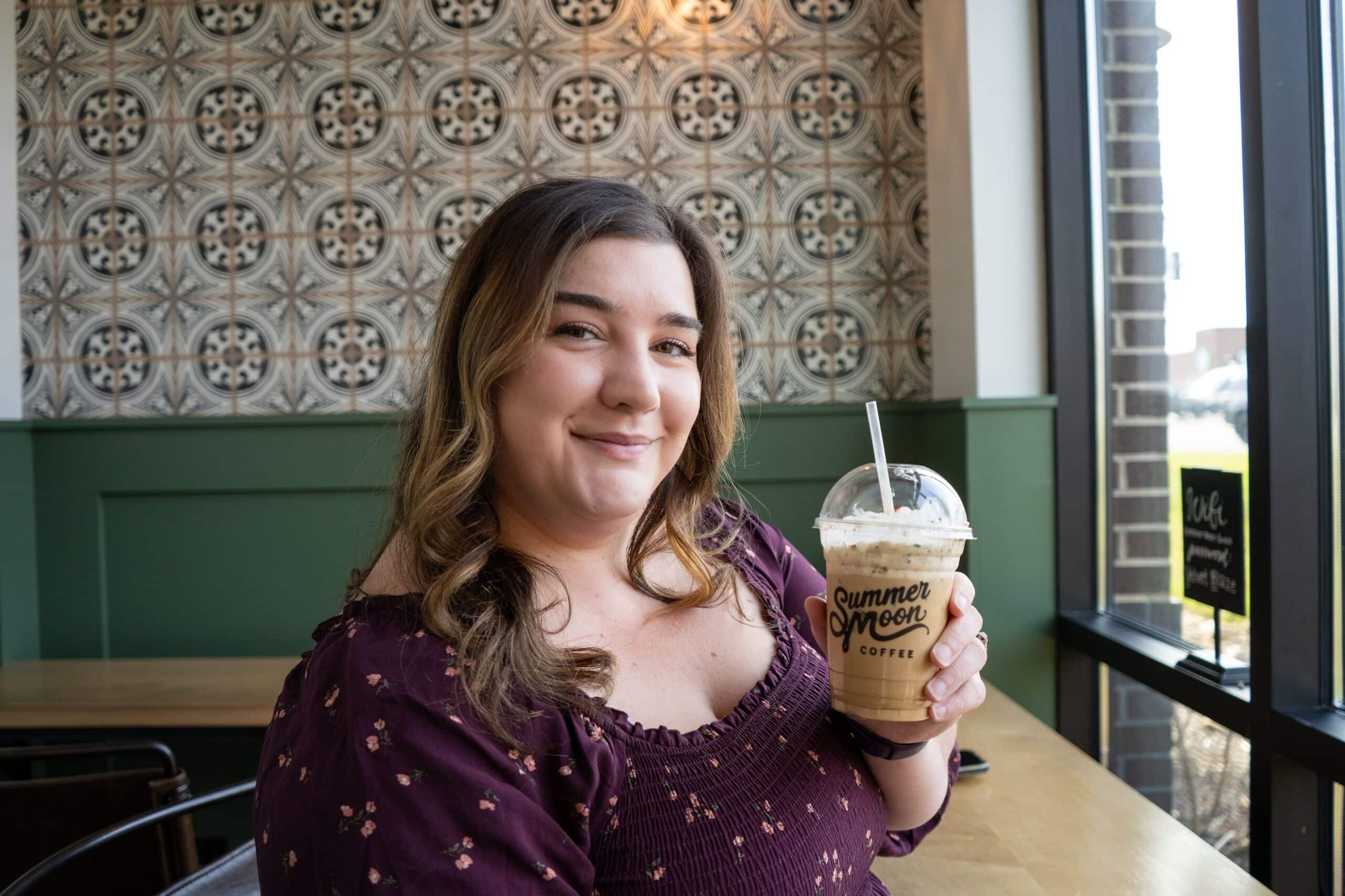 Woman holding coffee inside Summer Moon Coffee in Farragut