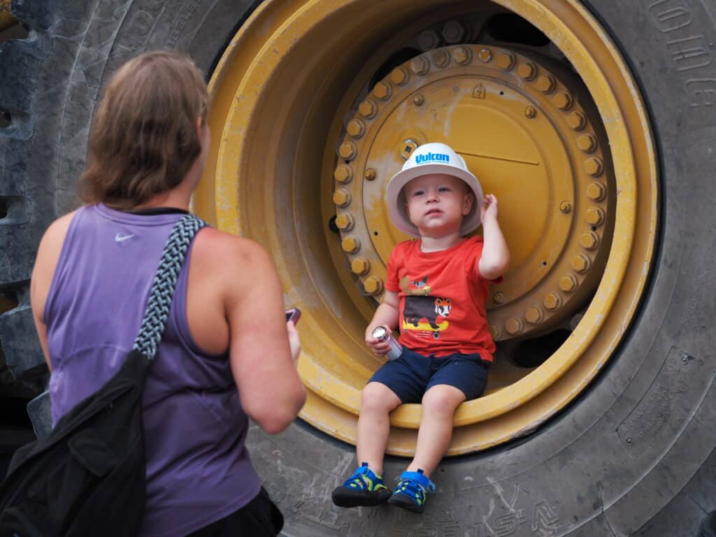 Little boy sitting inside big tire at Fun with Farragut's Fleet