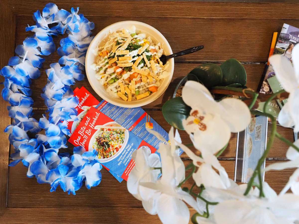 A poke bowl next to a lei from Island Fin Poke, an affordable place to eat in Farragut. 