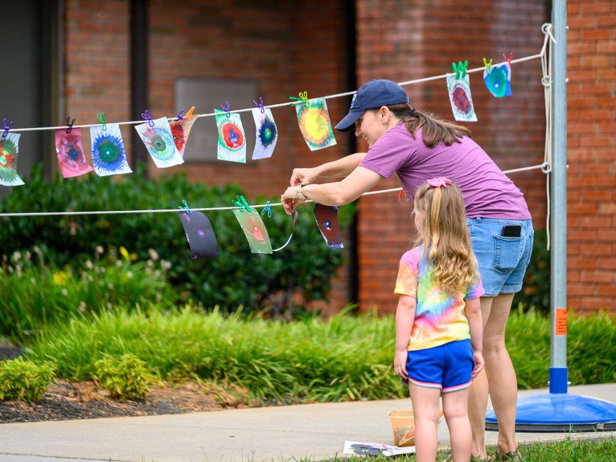 A mother and daughter hanging artwork made at a Farragut Community Center art event.