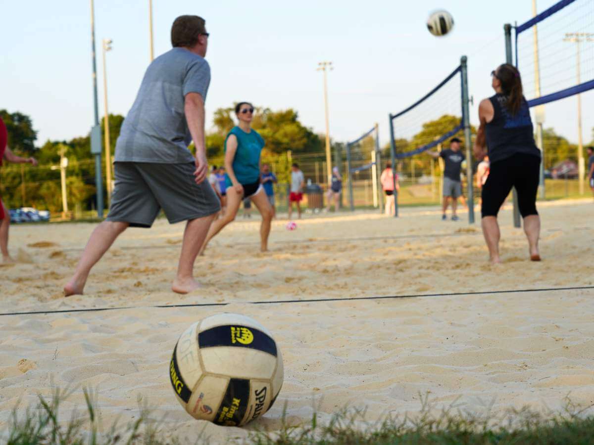 People playing on the sand volleyball courts at a Farragut park.