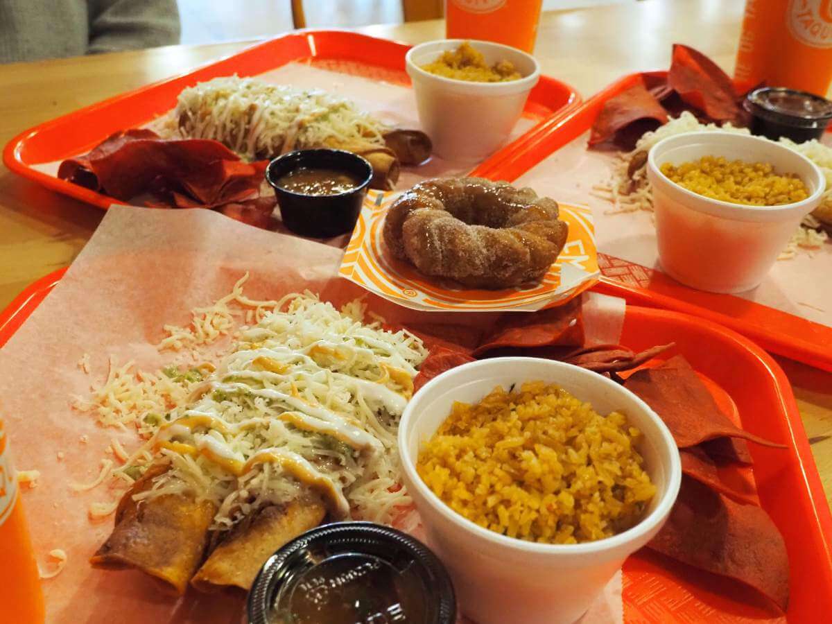 Plates of taquitos, rice, and a churro donut from Roll-Em-up Taquitos in Farragut.