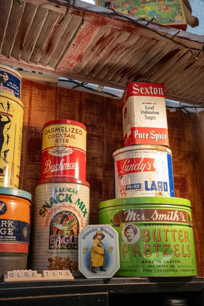 A collection of odd vintage cans including snack mix, butter pretzels, pure spice, lard, and more.