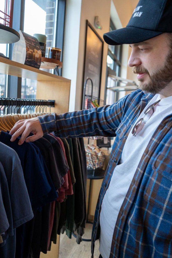 Man looking through t-shirt rack at Summer Moon